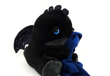 A black Sleepy Dragon with blue eyes and blue blanket